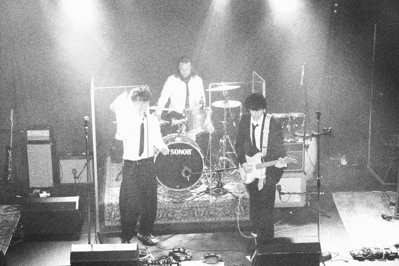 Kemlo and full band mid set under stage lights