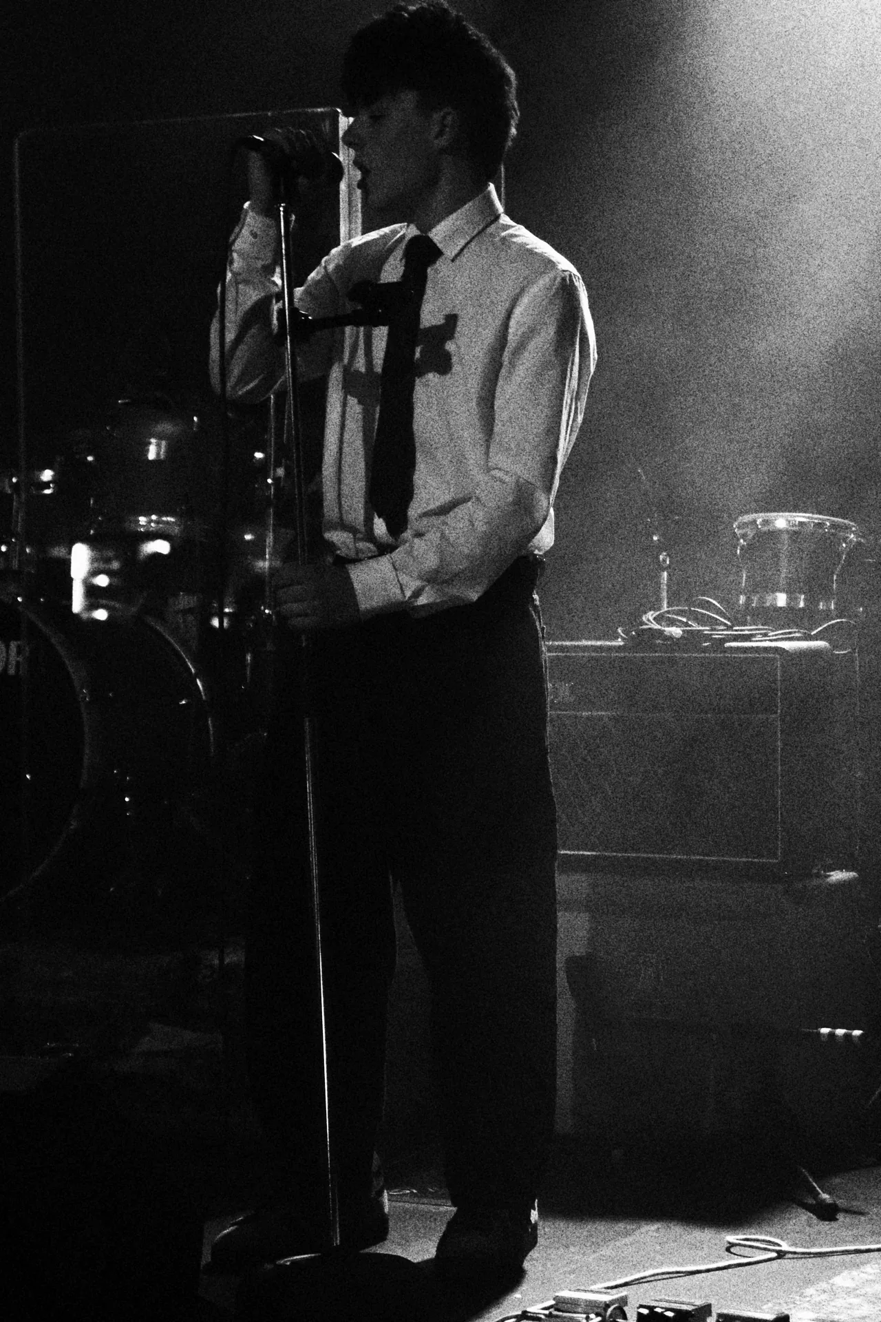 Kemlo singing into the microphone under hazy stage light